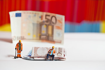 Image showing Miniature people in action with euro banknotes