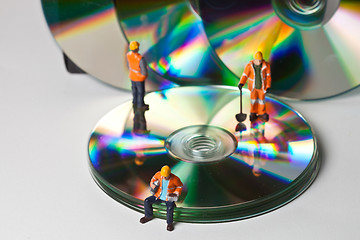 Image showing Miniature people in action with CDs