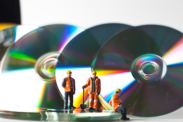 Image showing Miniature people in action with CDs