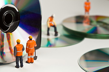 Image showing Miniature people in action with CDs