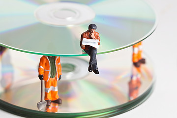 Image showing Miniature people in action with CDs