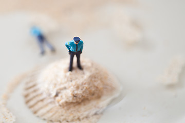 Image showing Miniature policeman on a stack of sand while one is lying dead i