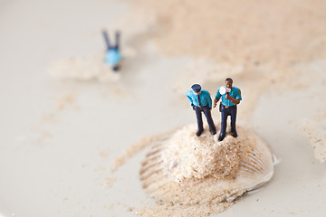 Image showing Miniature policeman on a stack of sand while one is lying dead i