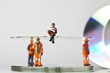 Image showing Miniature people in action with CDs