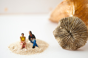 Image showing Miniature people sitting on a stack of sand