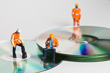 Image showing Miniature people in action with CDs