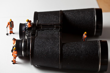 Image showing Miniature people in action with magnification glasses