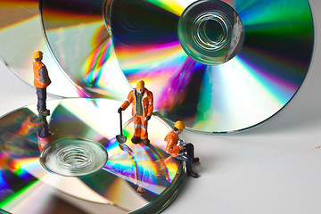 Image showing Miniature people in action with CDs