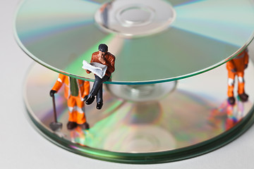 Image showing Miniature people in action with CDs