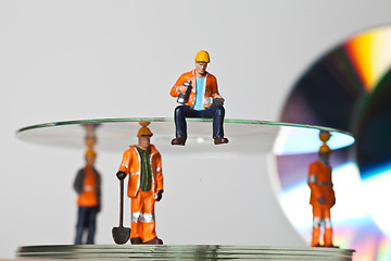 Image showing Miniature people in action with CDs