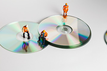 Image showing Miniature people in action with CDs