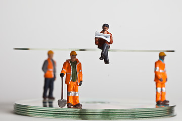 Image showing Miniature people in action with CDs