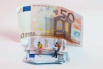 Image showing Miniature people in action with euro banknotes