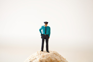 Image showing Miniature policeman on a stack of sand 