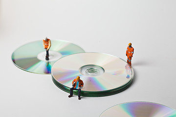 Image showing Miniature people in action with CDs