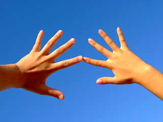 Image showing Man's and female hands on a background of the blue sky