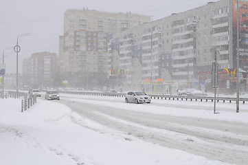 Image showing The cars brought by snow, stand on a road roadside.