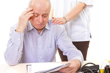 Image showing doctor comforting mature stressed patient with headache
