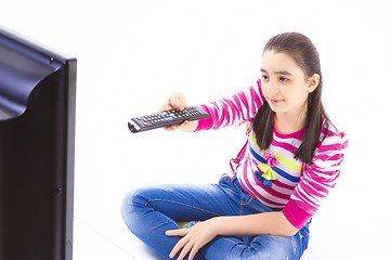 Image showing Happy little girl laying down and watching tv