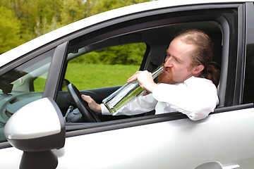 Image showing Drunk man in car with a bottle alcohol