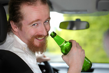 Image showing Drunk man in car with a bottle beer