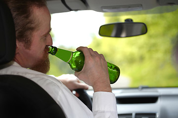 Image showing Drunk man in car with a bottle beer