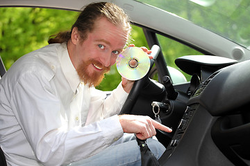 Image showing driver with CD, playing music in the car