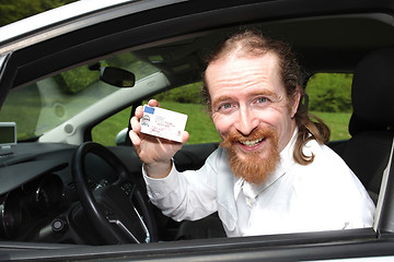 Image showing driver smiling sitting in car and showing drivers license