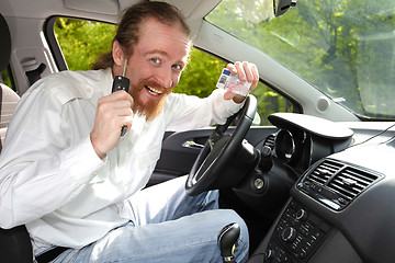 Image showing driver smiling sitting in car and showing new car keys and drive