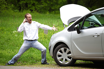 Image showing Driver furious with mobile phone a broken car by the road 