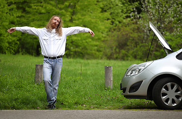 Image showing Funny driver praying a broken car by the road  