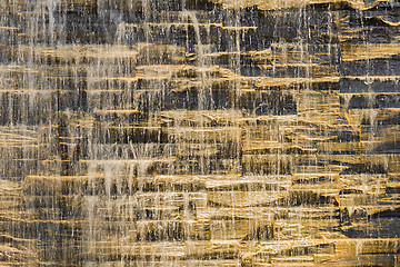 Image showing Falling water stream against stonework rough texture