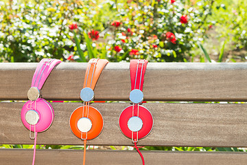 Image showing Three varicolored headphones of different colors