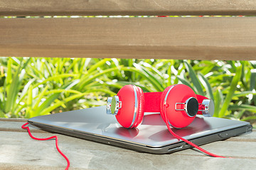Image showing Colorful red headphones and notebook