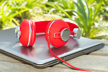 Image showing Vivid red headphones and laptop