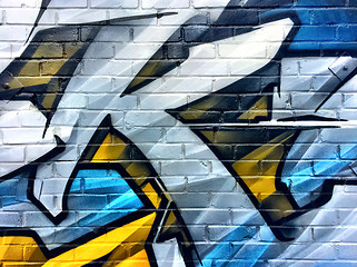 Image showing Blue and yellow graffiti detail on a brick wall