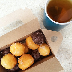 Image showing Cup of tea and box of sweet doughnuts