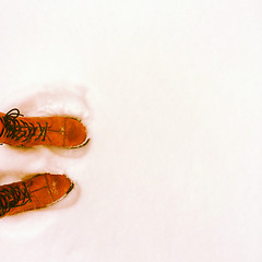 Image showing Person in orange boots standing in the snow