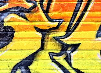 Image showing Black and yellow graffiti detail on a brick wall