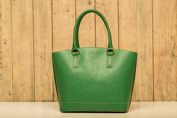 Image showing green purse on wood background