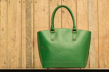 Image showing green purse on wood background