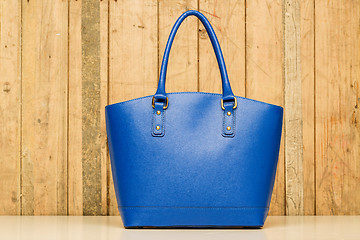 Image showing blue purse on wood background