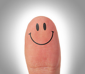 Image showing Female thumbs with smile face on the finger