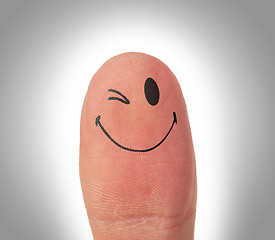 Image showing Female thumbs with smile face on the finger