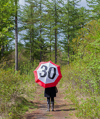 Image showing Woman in the forrest with a traffic sign umbrella