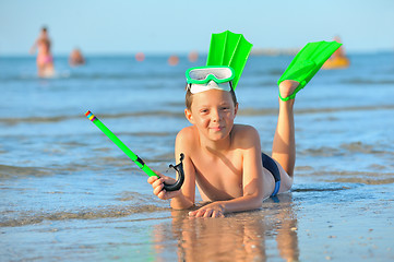 Image showing  boy with  swimming goggles, snorkel swimming and flippers 