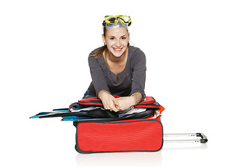 Image showing Happy female packing her suitcase