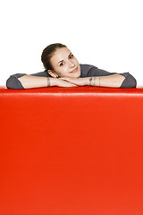 Image showing Woman leaning on the red leather couch