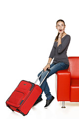 Image showing Happy female on sofa with suitcase