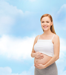 Image showing happy future mother touching her belly